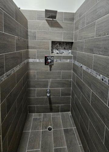a bathroom with a shower with brown tiles at Ihola's Nest in Craighton