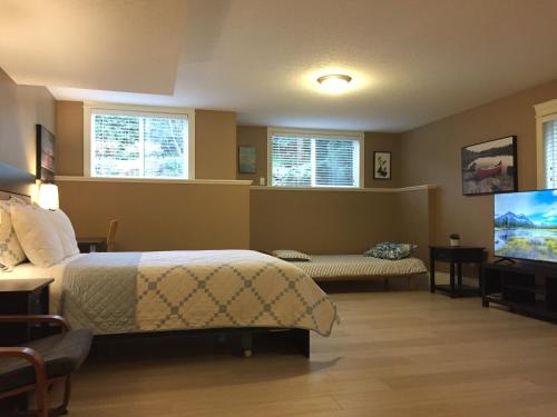 a bedroom with a bed and a flat screen tv at NeckPoint Treasure BnB in Nanaimo