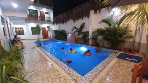 a group of people playing in a swimming pool at Hospedaje Ola Marina in Máncora