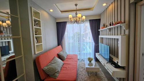 a living room with a red couch and a window at The Blu X Seaview บางแสน F5 R140 in Ban Bang Saen (1)