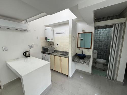 a white kitchen with a sink and a toilet at Atelier- Bohardilla a 2 cuadras de la plaza principal in Salta