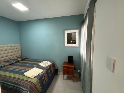 a blue bedroom with a bed and a nightstand with a table at Atelier- Bohardilla a 2 cuadras de la plaza principal in Salta