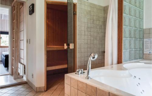 a bathroom with a tub and a shower at Holiday Home Bellisvej Tranekær Ix in Skattebølle