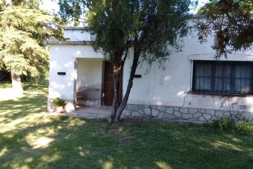 un piccolo edificio bianco con un albero nel cortile di Casa amplia en las sierras de San Luis a San Francisco del Monte de Oro
