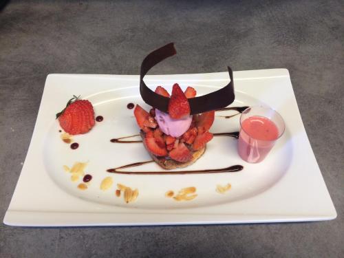 a plate with a dessert with strawberries on it at Hotel du Golf de Clécy in Clécy