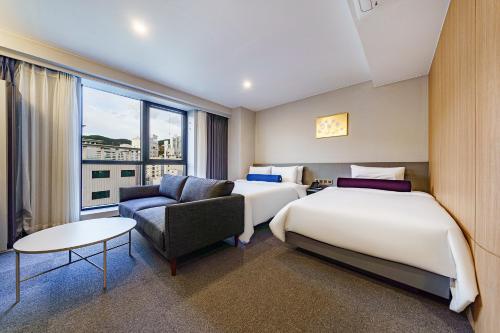 Habitación de hotel con 2 camas y sofá en Hound Hotel Hadan, en Busan