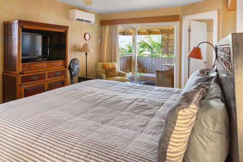 Orchid Suite in South Maui, across from the beach, 1 bedroom sleeps 4 في كيهي: غرفة نوم بسرير كبير وتلفزيون