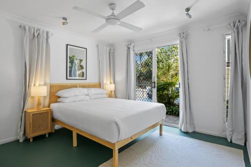 a white bedroom with a bed and a window at Urban Apartment in the Heart of Paddington in Brisbane