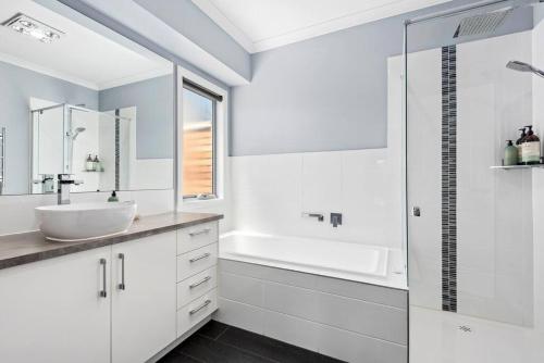 a white bathroom with a sink and a shower at Hood Road Beach House- Hamptons inspired sleeps 9 in Indented Head