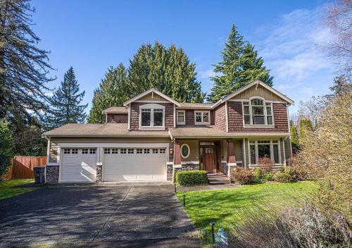 a house with a car garage in a yard at Kirkland's Expansive Custom-Built Family Haven Near Juanita in Kirkland