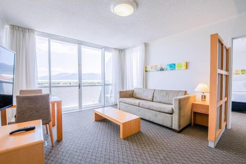 a living room with a couch and a table at Cairns Harbourside Hotel in Cairns