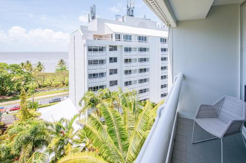 a balcony with a view of a building and the ocean at Cairns Harbourside Hotel in Cairns