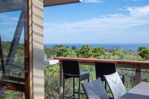 a balcony with chairs and a view of the ocean at TJ's Tree House with Ocean Views in Cape Schanck