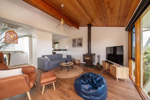 a living room with a couch and a tv at TJ's Tree House with Ocean Views in Cape Schanck