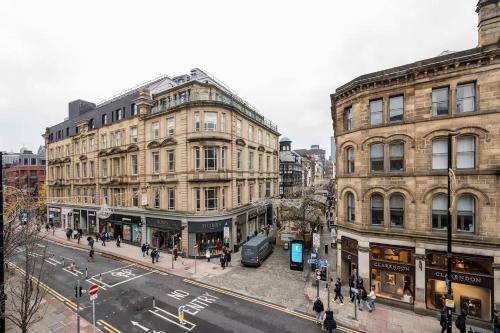 a city street with buildings and people walking on the street at Deansgate Luxury Apartments in Manchester