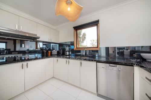 a large kitchen with white cabinets and a window at TJ's Tree House with Ocean Views in Cape Schanck