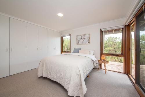 a bedroom with a large bed and a window at TJ's Tree House with Ocean Views in Cape Schanck