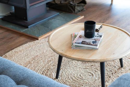 a coffee table with a cup and magazines on it at TJ's Tree House with Ocean Views in Cape Schanck