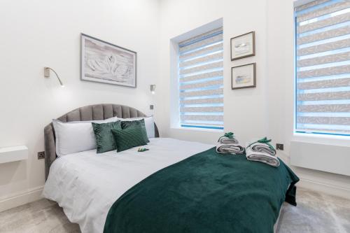 a bedroom with a large bed with a green blanket at Deansgate Luxury Apartments in Manchester