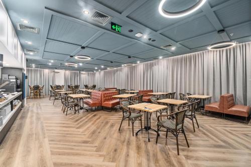 a restaurant with tables and chairs in a room at Mercure Pakenham in Pakenham