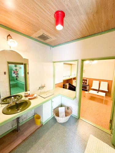 a bathroom with a sink and a mirror at ホテル亀岡 in Minamijō