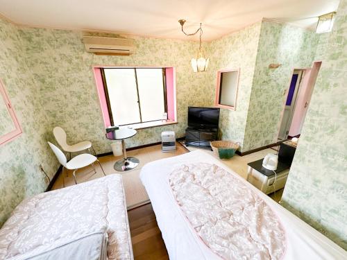 a bedroom with a bed and a living room at ホテル亀岡 in Minamijō