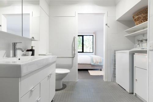 a white bathroom with a toilet and a sink at Hadspen Riverview Retreat: 2 Bedroom Unit in Hadspen