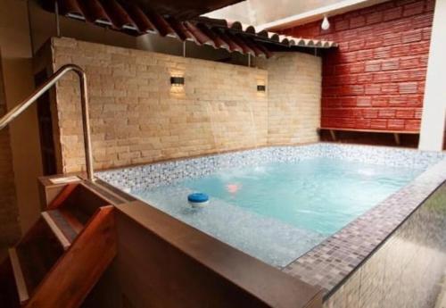 bañera de hidromasaje en una habitación con pared de ladrillo en Casa de Lujo 5 estrellas !, en Iquitos