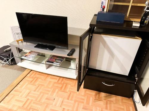 a entertainment center with a large tv on a table at Hotel Rakusai in Kyoto