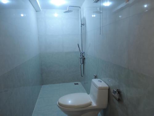 a white bathroom with a toilet and a shower at Vang Vieng Sky Mountain View Hotel in Vang Vieng