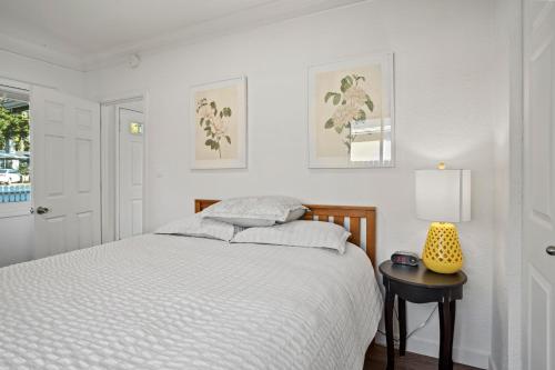 een witte slaapkamer met een bed en een tafel bij Southern Oregon Gem in Medford