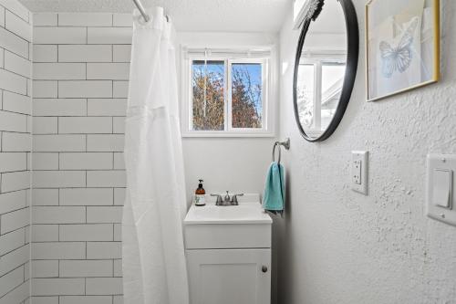 een witte badkamer met een wastafel en een spiegel bij Southern Oregon Gem in Medford
