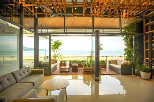 una sala de estar de planta abierta con vistas al océano en DA NANG BAY HOTEL, en Da Nang