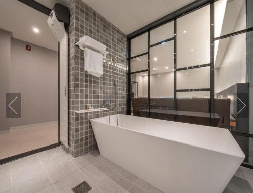 a bathroom with a large white tub in a room at Dongdaemun Saturn Hotel in Seoul