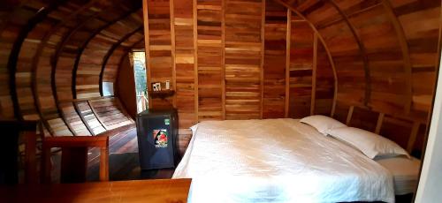 a bedroom with a bed in a wooden room at Green Bamboo Lodge Resort in Cat Tien