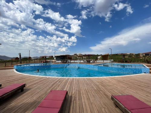 una gran piscina en una terraza de madera en Don Tomas Viñedo cabañas, en Valle de Guadalupe