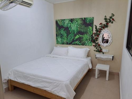 a bedroom with a bed and a painting on the wall at LittleBee Homestay KT in Kota Tinggi