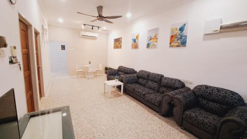 a living room with a couch and a ceiling fan at LittleBee Homestay KT in Kota Tinggi