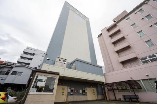 a tall building in the middle of two buildings at Hotel Ace Morioka in Morioka
