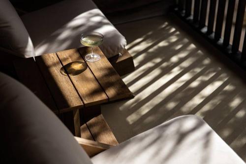 a glass of wine sitting on a wooden table at SABI Award Winning Designer Cabin in Binalong Bay