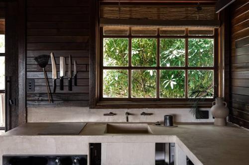 a kitchen with a sink and a window at SABI Award Winning Designer Cabin in Binalong Bay