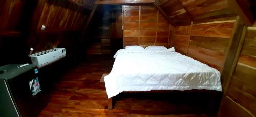 a bedroom with a bed in a wooden room at Green Bamboo Lodge Resort in Cat Tien