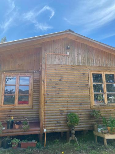 Casa de madera con 2 ventanas y porche en Rumiloft Cabañas, en Valdivia