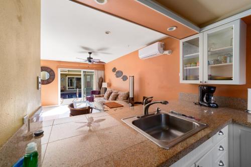 cocina con fregadero y sala de estar. en Gardenia Suite located across from beach in a boutique property, en Kihei