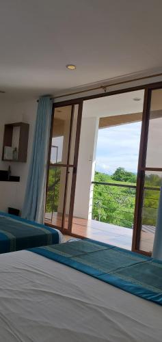 a bedroom with two beds and a large window at The Boathouse at Calatagan in Sipating