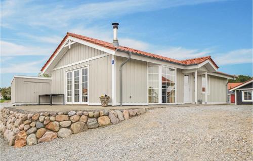 a house with a stone wall in front of it at Marina Fiskenæs Feriepark in Gråsten