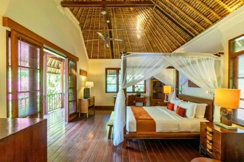 a bedroom with a bed with a canopy at Magnificent 4 BR Private Pool Villa NE10 in Jimbaran