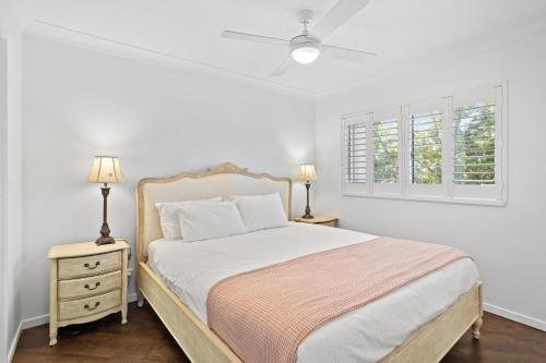 una camera bianca con un letto e due comodini di Coastal 1-Bed Apartment with Pool & Tennis Court a Gold Coast