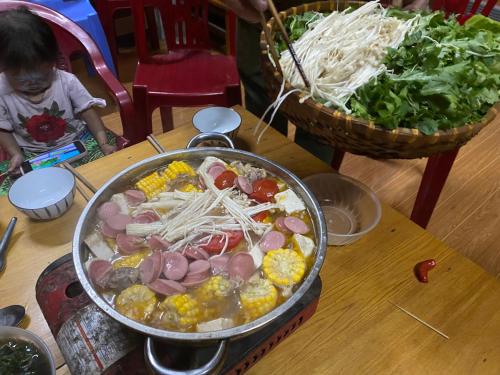 a large pot of food on a table with a child at Sue Pa Family Trekking Homestay in Sa Pả