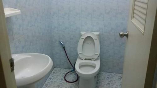 La salle de bains est pourvue de toilettes blanches et d'un lavabo. dans l'établissement KhopChai Guesthouse, à Houei Sai